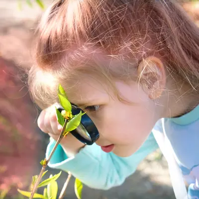 Image of Girl with Magnifying Glass and Plants